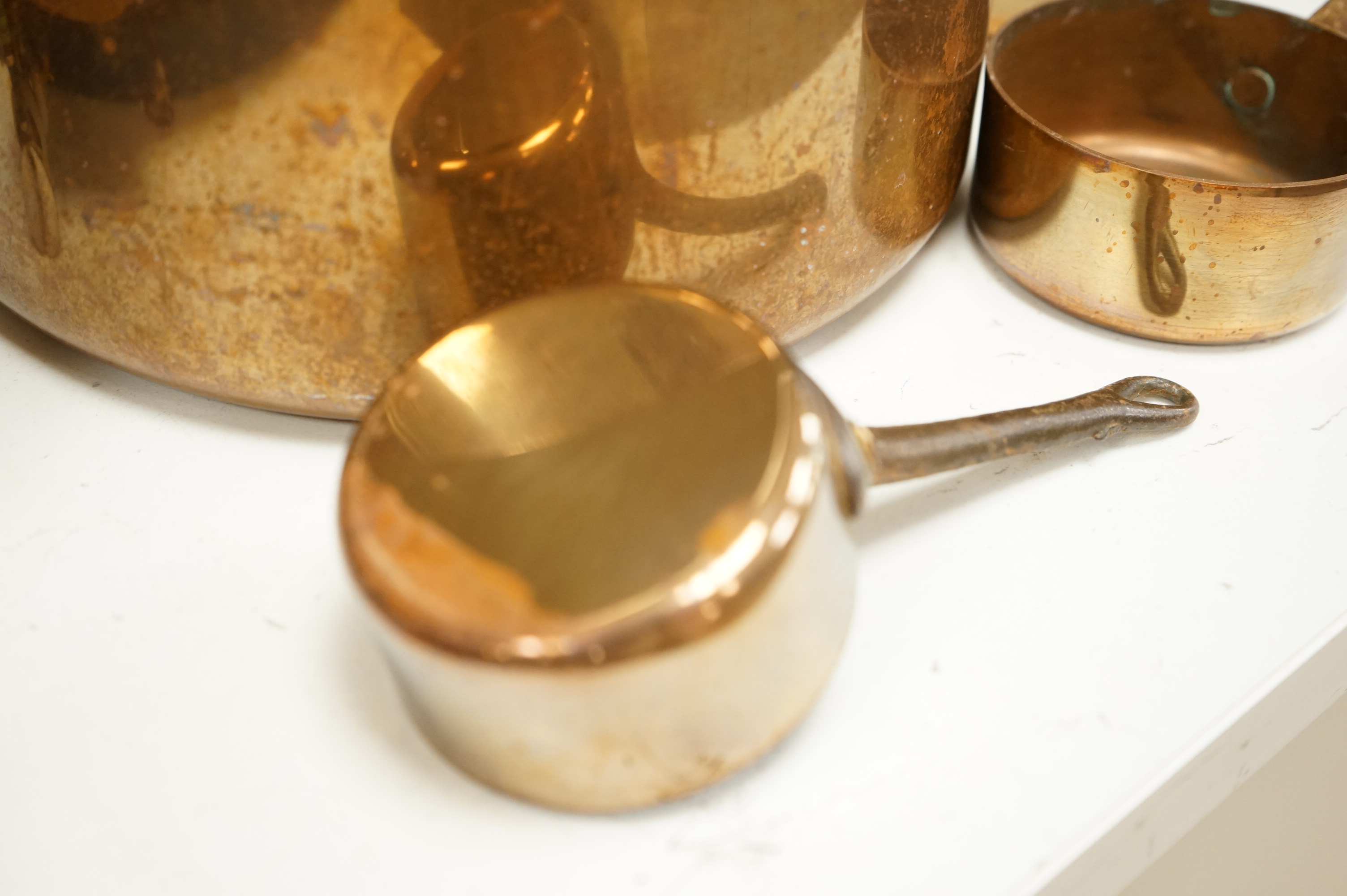 A graduated set of copper saucepans, largest 20.5cm diameter, smallest 6.5cm
